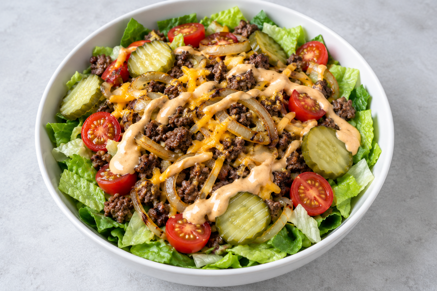 Browned ground beef with cheddar, griddled onions, romaine, cherry tomatoes, dill pickles, and a creamy burger sauce